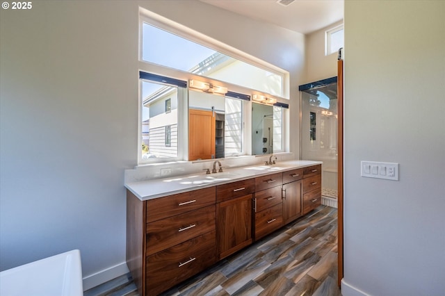 760 Carter St SW, Bandon, OR 97411 - bathroom with healthy amount of natural light, double vanity, wood finished floors, and baseboards