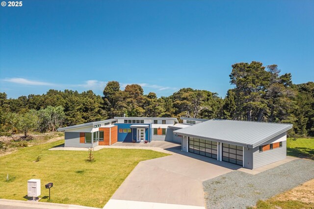 760 Carter St SW, Bandon, OR 97411 - contemporary house with concrete driveway, a front yard, a garage, and metal roof