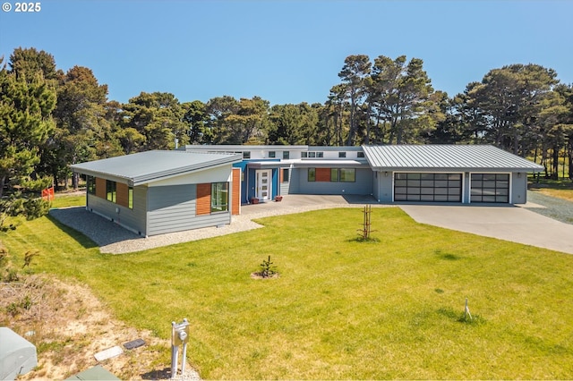 760 Carter St SW, Bandon, OR 97411 - view of front of house featuring driveway, a front lawn, a garage, metal roof, and view of scattered trees