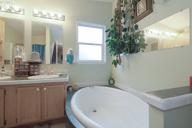 bathroom featuring vanity, lofted ceiling, and tiled bath