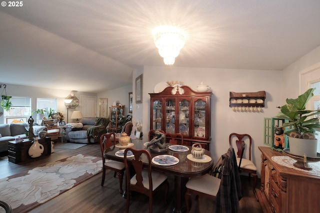 dining room with dark wood-type flooring and a notable chandelier