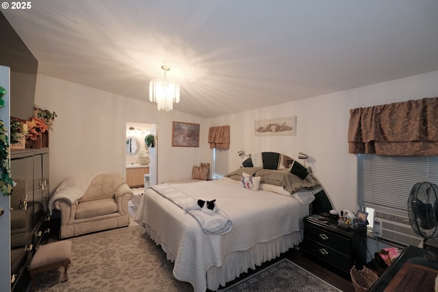 bedroom with cooling unit, connected bathroom, and a notable chandelier