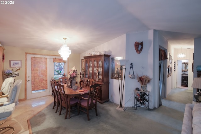 carpeted dining area with lofted ceiling and a chandelier