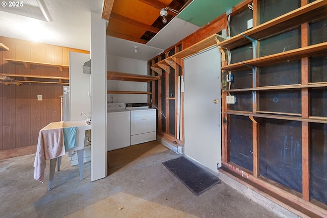 basement with wooden walls and washer and clothes dryer