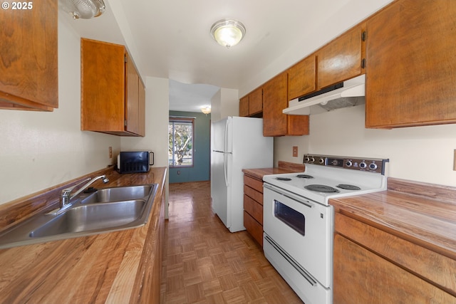 kitchen with sink, white appliances, and parquet flooring