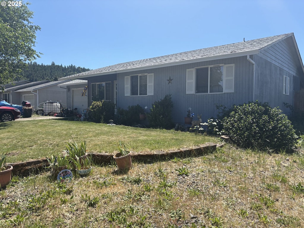 253 S Grove Ln, Sutherlin, OR 97479 - view of front facade with a front yard, roof with shingles, and an attached garage