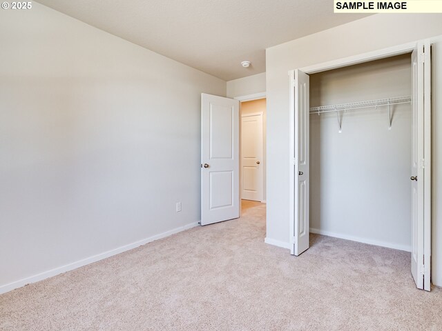2133 NE 4th Ave, Battle Ground, WA 98604 - unfurnished bedroom with light colored carpet, a closet, and baseboards