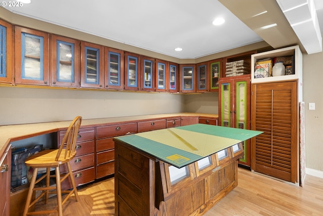 kitchen featuring a kitchen island, built in desk, and light hardwood / wood-style floors