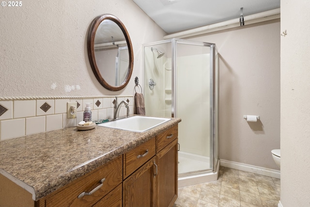 bathroom with walk in shower, toilet, vanity, and decorative backsplash