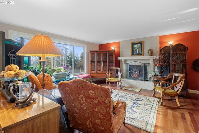 living room featuring a brick fireplace and hardwood / wood-style flooring