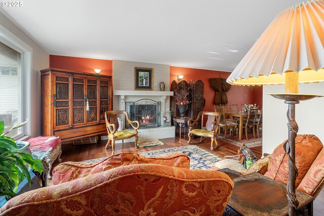 living room featuring a brick fireplace and hardwood / wood-style flooring