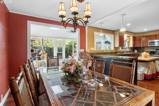 dining space with wood-type flooring, sink, and crown molding