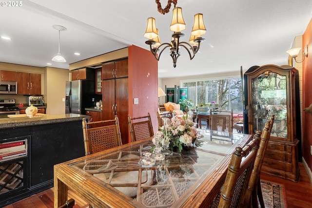 dining room with dark wood-type flooring and a notable chandelier