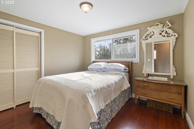 bedroom with crown molding, dark wood-type flooring, and a closet