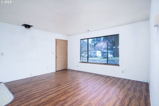 spare room with dark wood-style floors and baseboards