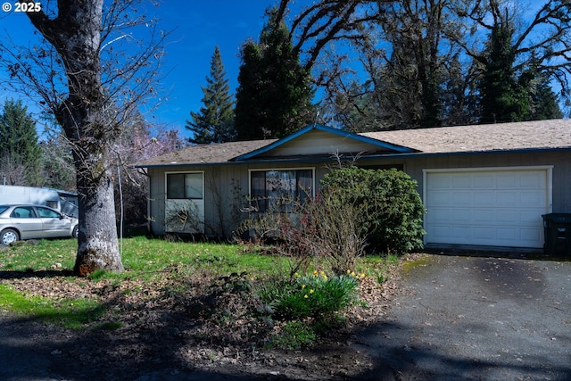 ranch-style home featuring aphalt driveway and an attached garage