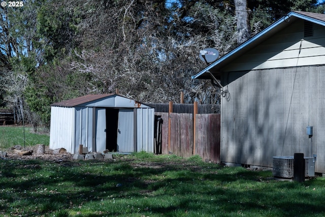 view of shed featuring central air condition unit and fence