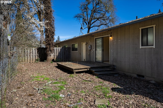 rear view of house featuring fence private yard and a deck