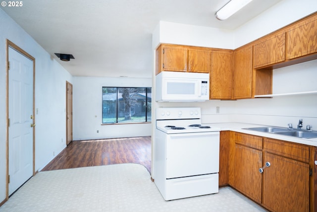 kitchen with a sink, open shelves, white appliances, brown cabinetry, and light floors