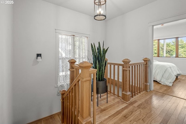 hallway with an upstairs landing and light wood-type flooring