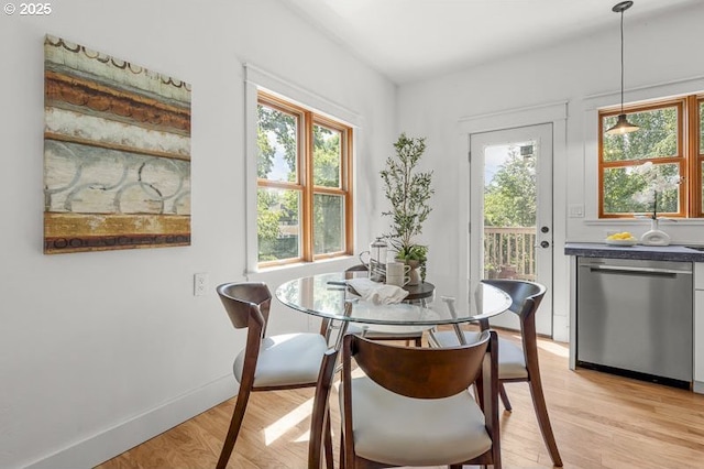 dining space featuring light wood finished floors and baseboards