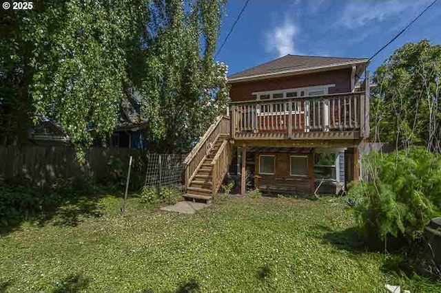 back of property with a deck, stairs, and a yard
