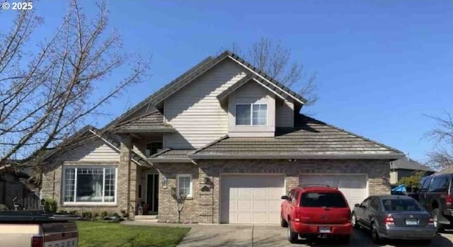 view of front of property featuring concrete driveway, brick siding, and a garage