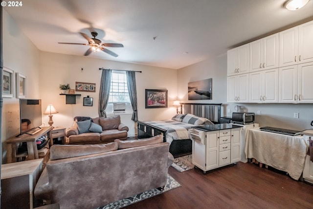 living area with cooling unit, a ceiling fan, a toaster, and dark wood finished floors