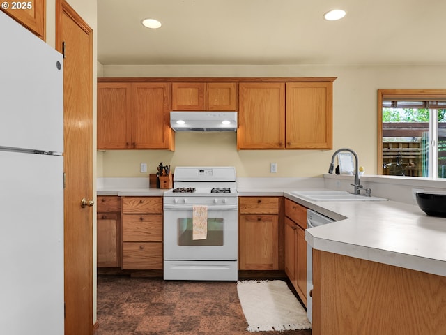 1305 Sandy Ridge Rd, Gearhart, OR 97138 - kitchen featuring white appliances, under cabinet range hood, light countertops, recessed lighting, and brown cabinetry