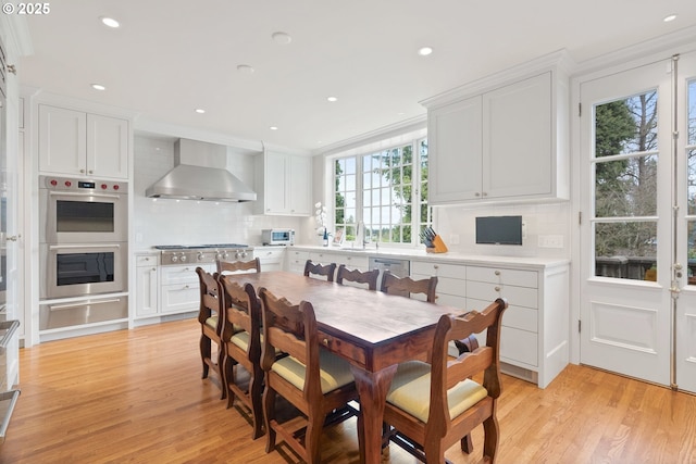 dining room featuring light wood-style flooring, ornamental molding, and recessed lighting