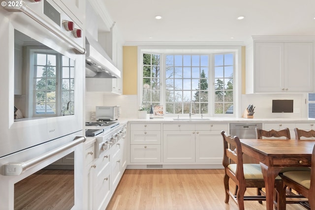 kitchen with light countertops, a sink, and white cabinets