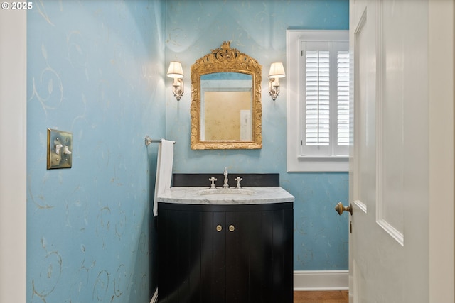 bathroom with a healthy amount of sunlight, vanity, and baseboards