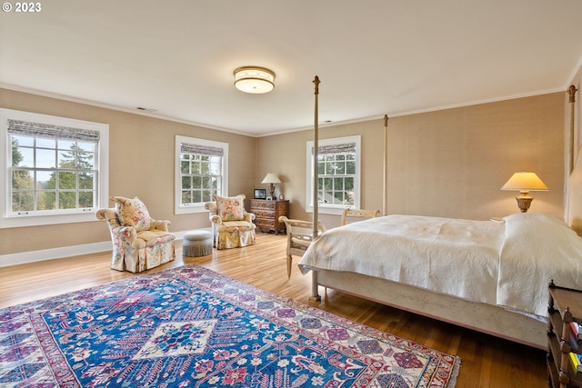 bedroom with multiple windows, crown molding, and wood finished floors