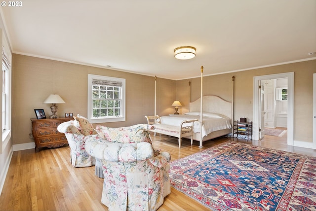 bedroom featuring baseboards, ornamental molding, and light wood-style floors