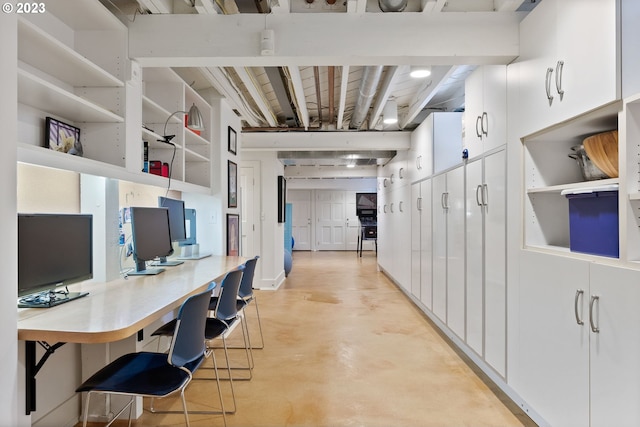 office space featuring finished concrete flooring and built in desk