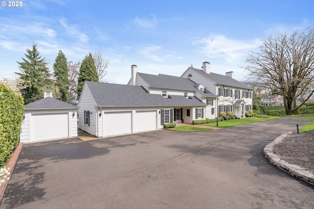 view of front of home with a shingled roof, a residential view, driveway, and a garage