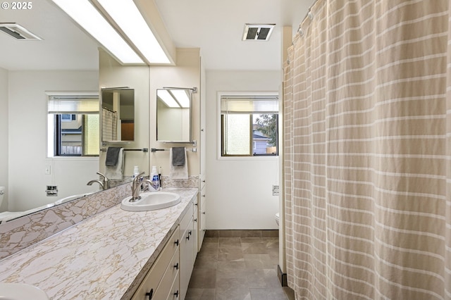 full bath with visible vents, vanity, toilet, and baseboards