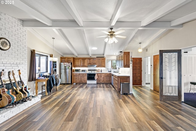 kitchen with electric stove, brown cabinetry, light countertops, and freestanding refrigerator