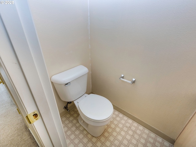 bathroom featuring toilet, tile patterned floors, and baseboards