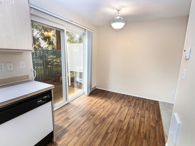 unfurnished dining area featuring wood finished floors and baseboards
