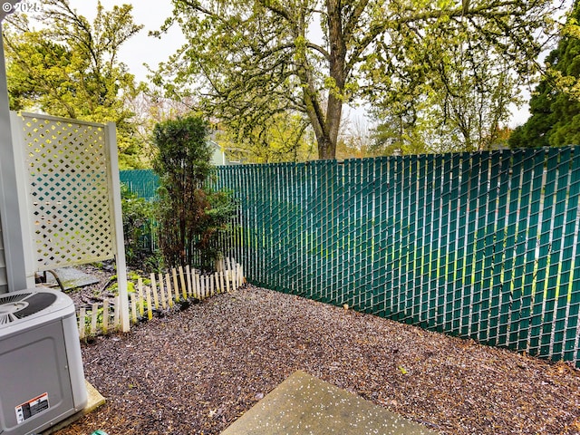 view of yard with central AC and a fenced backyard