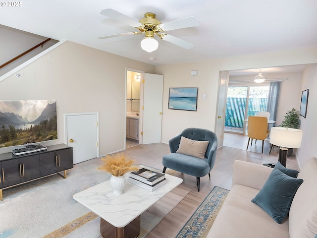 living room with light carpet, stairs, and ceiling fan