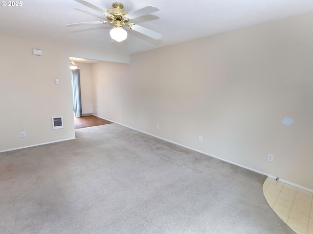 carpeted empty room with baseboards and a ceiling fan