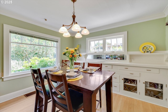 3034 NE Tillamook St, Portland, OR 97212 - dining area featuring light wood-style floors, healthy amount of natural light, ornamental molding, and a chandelier