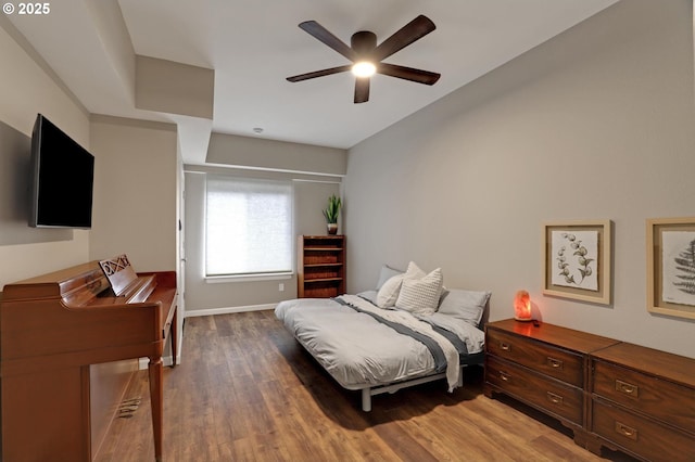 bedroom with a ceiling fan, baseboards, and wood finished floors