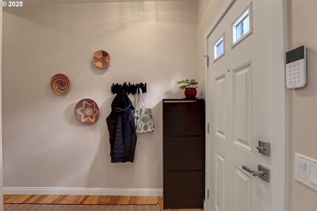 foyer entrance with wood finished floors and baseboards