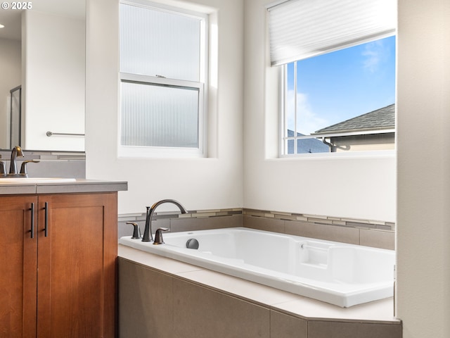 bathroom with vanity and tiled bath