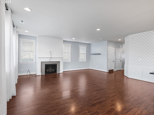 unfurnished living room with a large fireplace and dark hardwood / wood-style flooring