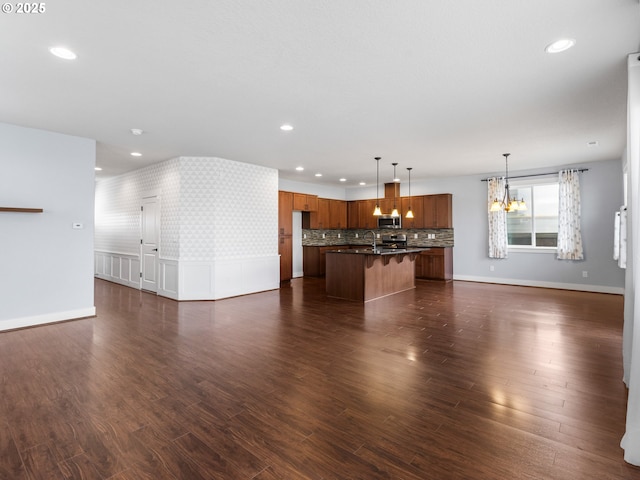 unfurnished living room with dark wood-type flooring, sink, and a notable chandelier