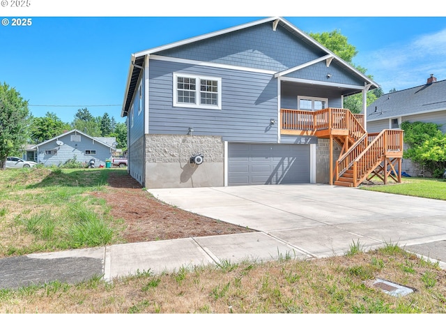 view of front of property with covered porch, an attached garage, concrete driveway, and stairs